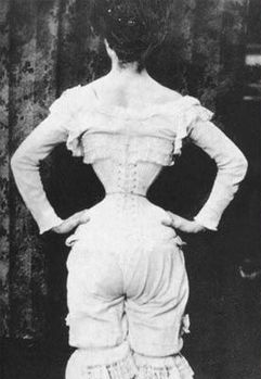 Kristin Holt | Corsets in the Era: Yes, even Maternity Corsets. Vintage image from the Victorian Era (or Edwardian Era) showing a woman's view from the back, dressed only in (a full compliment of) ladies underwear. We see her waist is constricted with a corset to a waspish, tiny circumference.