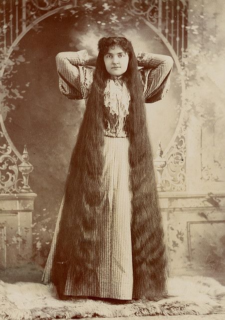 Kristin Holt | L-O-N-G Victorian Hair. Brunette with her hands behind her head, showing off her floor-length hair. By her dress, year is assumed to be mid 1890's. Image from Flicker and Pinterest.
