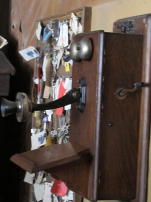 Kristin Holt | Historic Silver City, Idaho. Photo of a vintage telephone, with crank, mouthpiece, exposed bells, and wooden case. Telephone on display at The Idaho Hotel. Photographed by Kristin Holt, 2016.