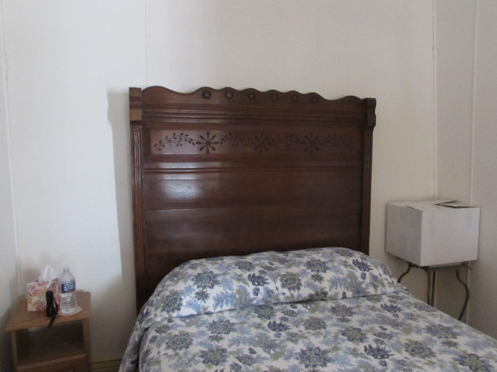 Kristin Holt | Historic Idaho Hotel in Silver City. Room #8: antique headboard (and foot board, not pictured). The box on the bedside table belonged to a guest; not part of the exquisite furnishings.