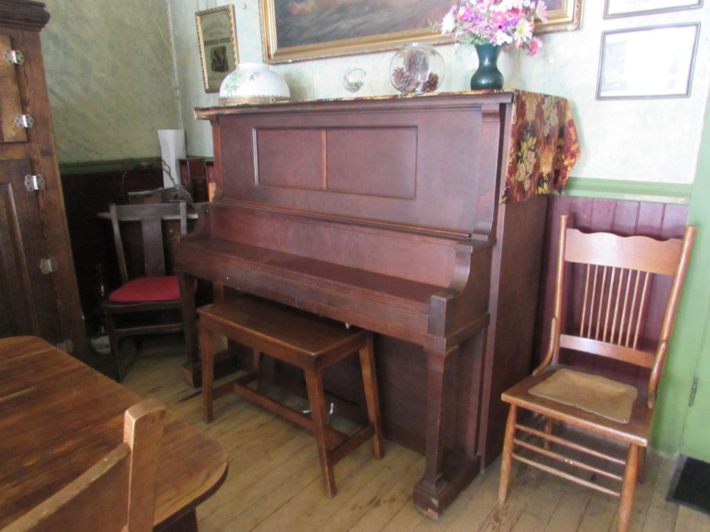 Kristin Holt | Historic Idaho Hotel in Silver City. Antique Upright Grand Piano, in the dining room of historic Idaho Hotel, Silver City, Idaho.