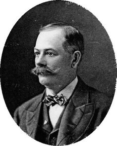 Kristin Holt | Victorian Era Men's Hairstyles. Vintage photograph of Sheridan Lockhart, 1900. Lockhart's hair is parted on the side, cut above the ears, and wears a full mustache.