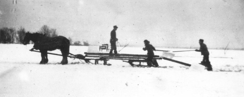 Kristin Holt | Nineteenth Century Ice Cutting. Vintage photograph: Men working together to load ice blocks onto a horse-drawn sleigh. Image source: McMaster University, Labour Studies, Courtesy of Worker's City, Canada.