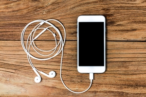 Kristin Holt | Book Review: Trio of Old West Tales. Photo of an iphone with connected earphones. Photo used by premium subscription agreement with Freepik.