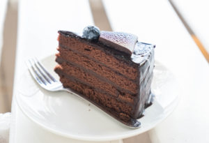 Kristin Holt | Victorian Baking: Devil's Food Cake ~ Image of chocolate fudge cake in cafe. Copyright listed, with photographer's name. Used from freepik's paid premium subscription.