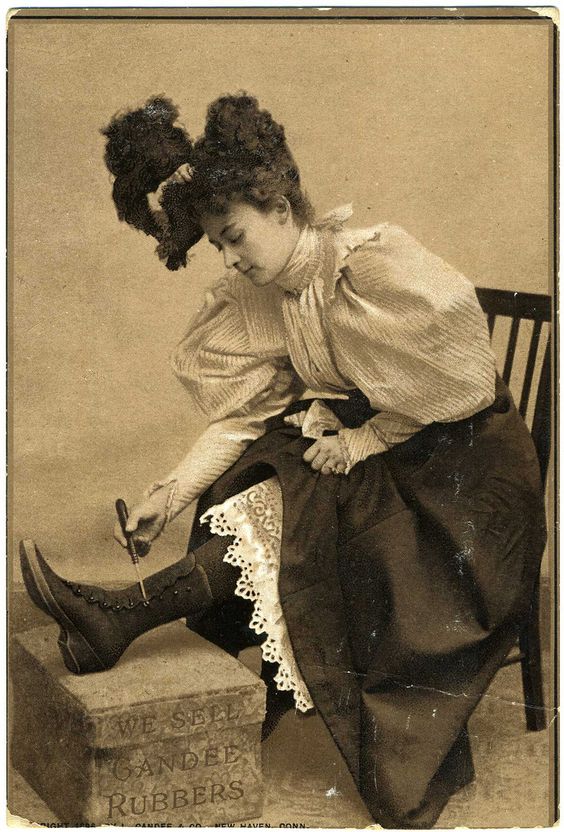 Kristin Holt | Ladies Fashions: Huge Sleeves of the 1890s. Vintage Advertisement: A photograph of an attractive young woman using button hook to button her boots. From Gandee Rubbers Boot Advertisement. Image: Pinterest.