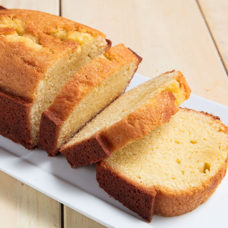 Photograph of a loaf Pound Cake cut into slices upon a serving plate. Photograph courtesy of Delish.com.